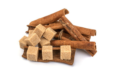 brown sugar cubes and cinnamon sticks on a white isolated background