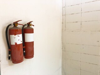 Old fire extinguisher on warehouse wall, fire extinguisher inspection not approved
