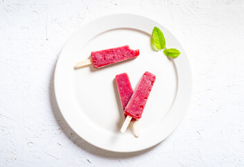 Delicious strawberry popsicles on white background