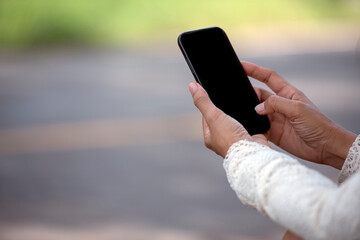 Asian woman using smartphone reading online social media shopping online website on smartphone with smile face. Happiness asian woman holding cellphone checking mail read Blog vlog social media