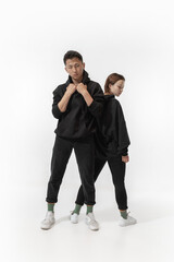 Inclusion. Trendy fashionable couple isolated on white studio background. Stylish woman and man posing in basic minimal stylish clothes equally suitable for both. Concept of equality, inclusive.
