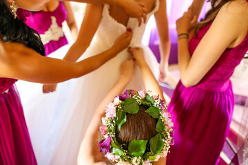bridesmaids helping bride to take the dress