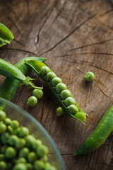 Close up of green peas on a wooden table. Rustic style.