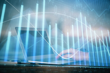 Double exposure of stock market graph with man working on laptop on background. Concept of financial analysis.