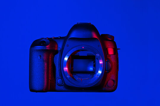Camera without lens mounted and visible mirror on blue background on glas panel