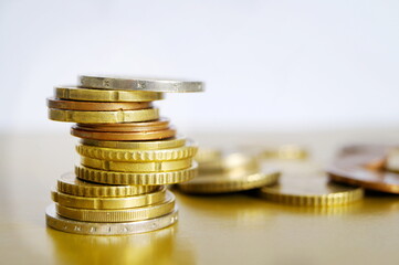 Coins are stacked on top of each other by a tower. Euro. Money. Close-up.