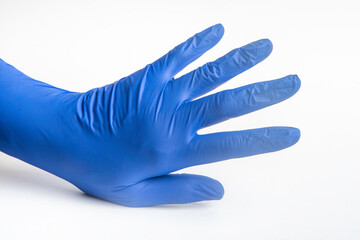 Fototapeta premium Hands wearing blue latex disposable gloves set on plain white background.