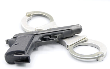 Gun and handcuffs isolated against a white background