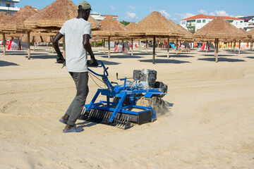 a man prepares the beach for summer holidays