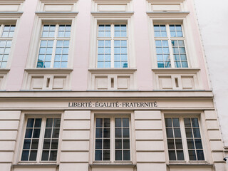 Facade of a historic Parisian building with the national motto of France 