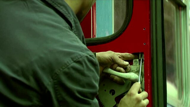 Worker fixes the lock on the door of the train