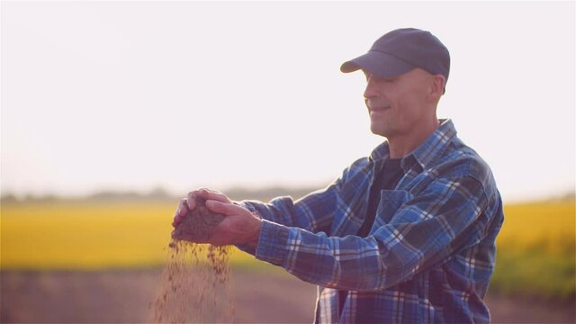 Farmer Examining Soild Dirt in Hands at Dusk