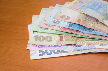 different hryvnias on a wooden table.