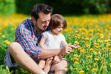 Naklejka na ściany i meble father and daughter on a field flowers