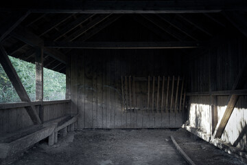 Fototapeta na wymiar A barn or feeding stall in black and white with the morning sun shining in.