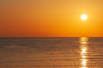 Fototapeta na wymiar Sunrise on the beach with a view of the sea and the sun
