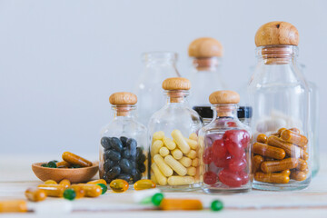 Close up pill and tablet medicine in glass bottle on wooden table. Medical concept, virus treatment, healthcare.