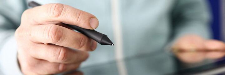 Male hand holding stylus going to make notes