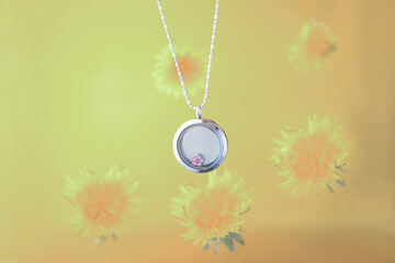 Silver necklace for her shining on yellow background with dandelions. Luxury silver jewelry chains with glass and crystals. Small Beautiful precious metal present for woman. Luxury expressions