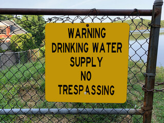 Yellow sign warning pedestrians not to walk in drinking water supply zone