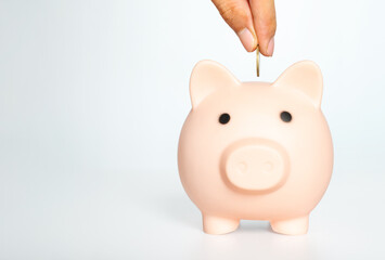 money saving for business investment finance and banking concept. people hands putting coin to piggy bank on table white room background.