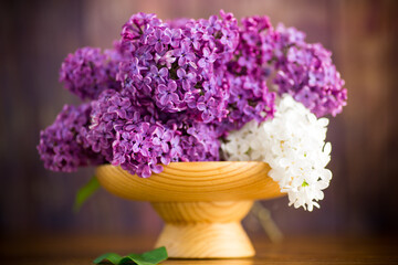 bouquet of beautiful purple lilacs in a wooden vase