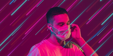 Man listen to music in headphones. Creative portrait with copyspace. Neon lighted, colored portrait with neon, flyer, proposal. Motion, action, youth culture concept. Contemporary art, modern design.