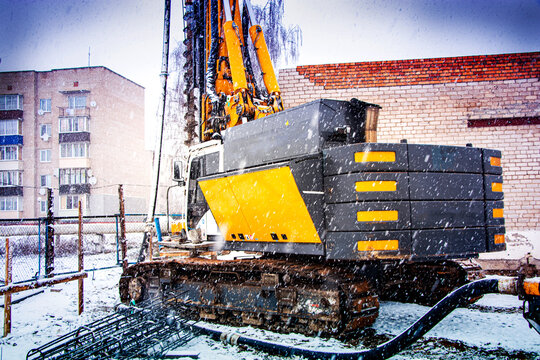 Crawler-mounted drilling rig. Foundations and foundation. Blurred image on the background of falling snow. Work in the north. Difficult working conditions.