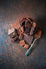 Dark and milk chocolate on a concrete background.