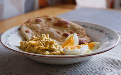 Hummus with eggs and pita on the retro plate. Jewish cuisine