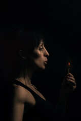 Obraz premium Mujer apagando llama en la oscuridad