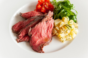 プレートに乗った肉料理付け合わせの野菜と赤ワイン