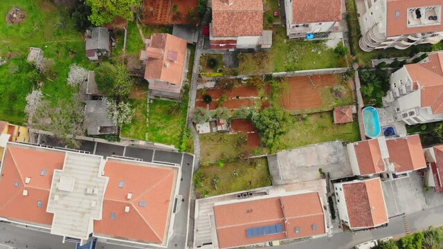 drone flying above small town in seacoast houses with orange roof tile view on the adriatic sea with boats