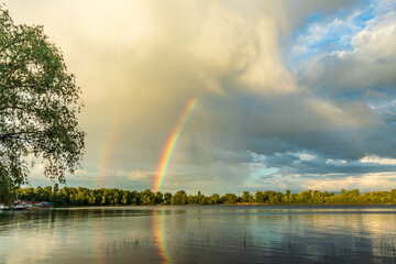 Rainbow after the summer rain over the river.