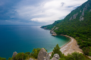 Fototapeta na wymiar Summer mediterranean coastal landscape. View of Cirali Beach from ancient Olympos ruins, with mountains and pine trees in background Antalya Turkey.