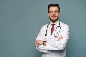 A portrait of a medical doctor posing against gray background