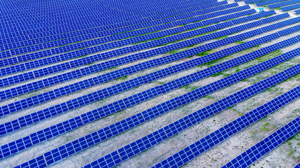 Background of solar pannels array as seen from above the modern static solar power station. Green energy background.