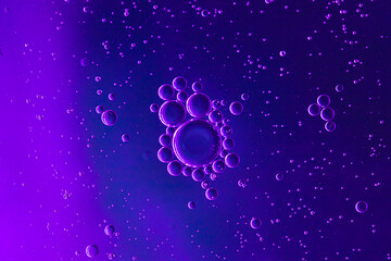 Blue background with oil circles . Bubbles of water. Close up.