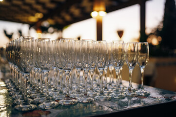 Many empty champagne glasses stand on table at party