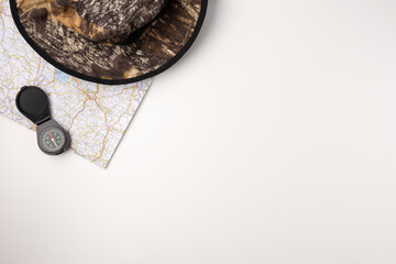 Flat lay travel map, hat and compas on white background. travel concept. © Konstantin Maslak