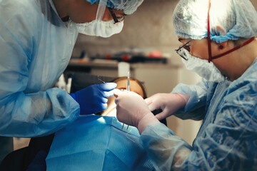 Dentist And Assistant Treat Teeth Of Little Girl