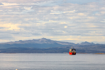 Fishing vessel navigates the Beagle Channel, near Ushuaia, with mountains in the background