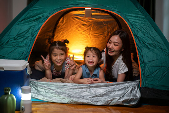 Asian woman playing and staying in tent with her daughter and having fun with camping tent in their bedroom a staycation lifestyle a new normal for social distancing in coronavirus outbreak situation