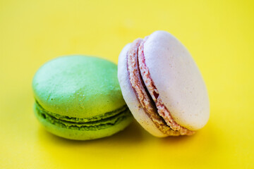 Many macaroons on a pink pastel background. Minimalism, eclairs and macaroons on a colored background