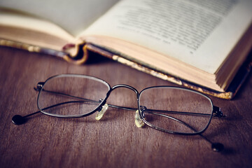 Spectacles and open old book, vintage, shallow DOF
