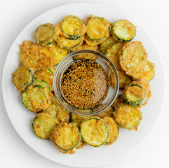 Korean fried zucchini on white plate with a sesame soy dipping sauce