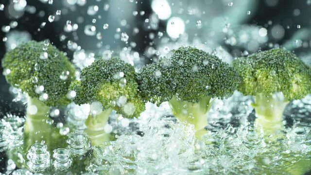 Water spinning off broccoli on blue background. Shot in slow motion with Phantom Flex 4K camera.