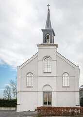 Fototapeta premium 18th century white church against white clouds and blue sky