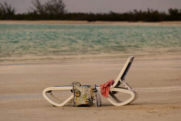 Fototapeta na wymiar Empty beach chair on the white sandy beach of the Caribbean