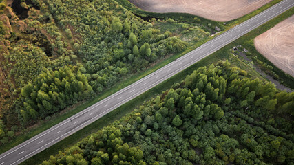 Aerial photo of a smooth asphalt road running through a field